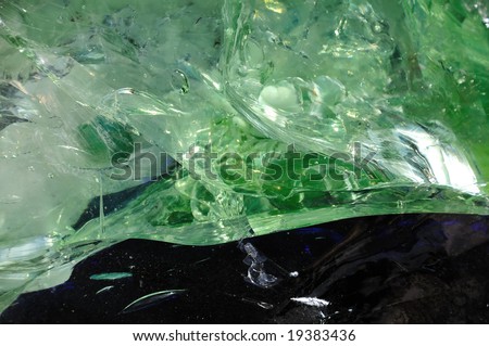 A macro image of a green gemstone rock surface made of glass-like material for use as a background texture or an overlay.