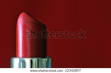 Red lipstick against a red background, macro image