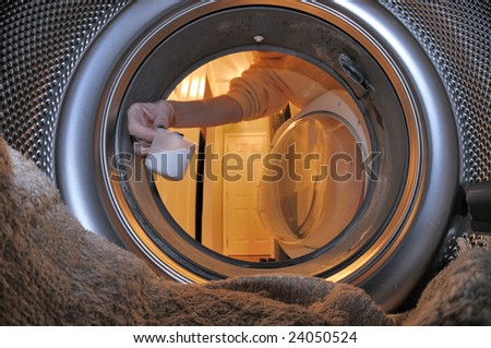 The interior of a front loading clothes washer while adding soap to the laundry load.