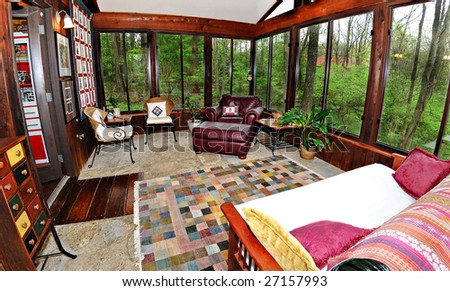 Home Interior shot of a patio sun room in a cedar log chalet home.