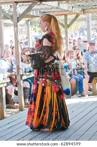 HARVEYSBURG OH-OCT 9:A belly dancer prepares to dance with a sword for the audience gathered under the canopy of the Aleing Knight Pub at the Ohio Renaissance Festival Oct 9, 2010 in Harveysburg OH