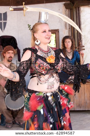 HARVEYSBURG OH-OCT 9:A belly dancer balances a sword on her head while performing at the Aleing Knight Pub after the gaming jousts at the Ohio Renaissance Festival Oct 9, 2010 in Harveysburg OH