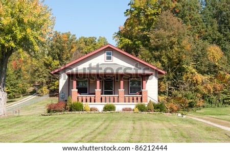 A 1930s Craftsman style house in the country in autumn.