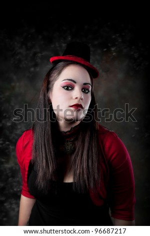 Beautiful young woman with red eyeshadow and red lips, wearing a red sweater and a hat with red trim.