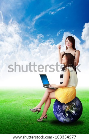 Two lady on grass field and hold notebook computer : Elements of this image furnished by NASA