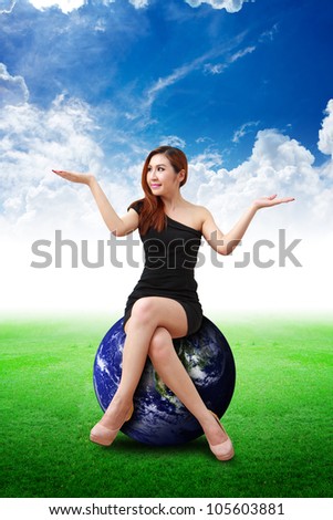 Lady on globe on the grass field : Elements of this image furnished by NASA