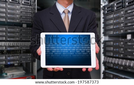 Business man in data center room with touch pad