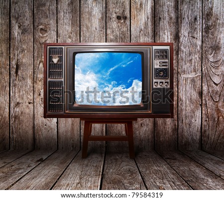 Old vintage TV in the Vintage wooden room on table with sky view