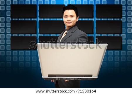 Smile Business man hold notebook computer and LCD monitor background