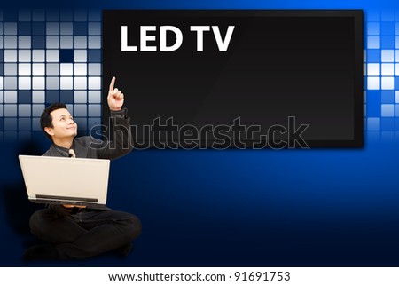 Smile Business man press button on notebook computer with digital LED TV