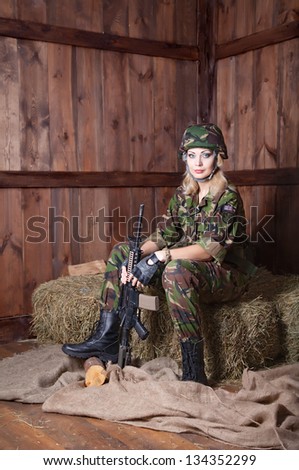 Military women with a weapon. Military women rest on straw