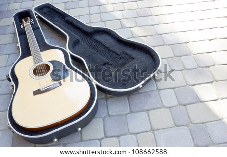 guitar in case resting on the street