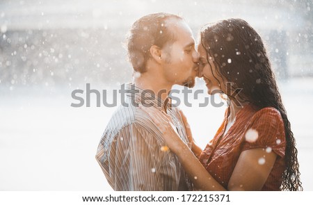 The girl with the boy kissing under a down-pour rain
