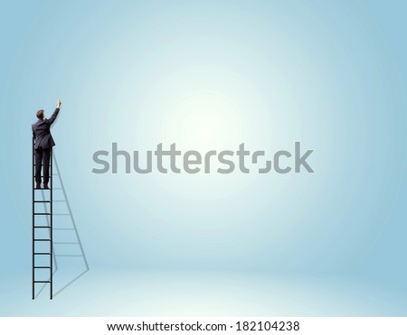 businessman standing on ladder and drawing on wall