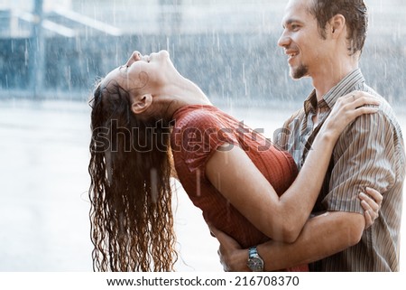 Love in the rain. Boy and a girl kissing in the rain