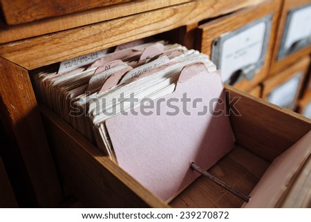 A file cabinet drawer full of files. shelf filled with files