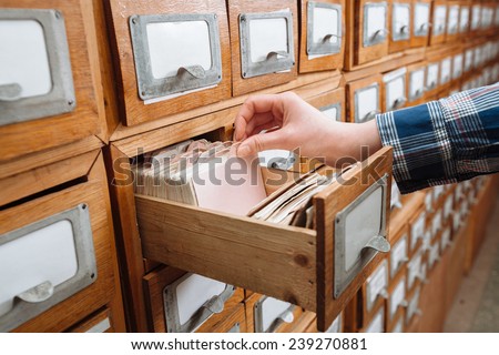 A file cabinet drawer full of files opened by hand