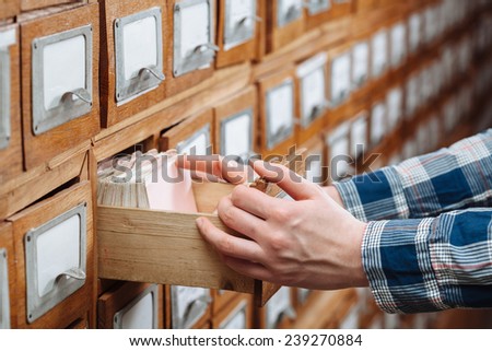 A file cabinet drawer full of files opened by hand