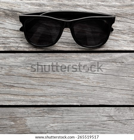 Eyeglasses Glasses with Black Frame Fashion Vintage Style on Wood Desk Background, backlit with copy space for text. square image