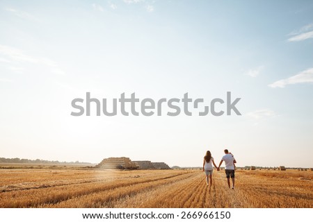 happy family having fun and walking on a field outdoors