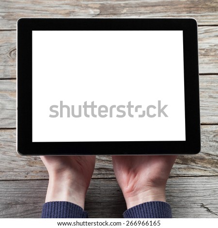 female hands holding digital tablet computer with isolated screen over old grey wooden background table with a cup of black coffee on the background