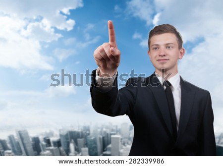 Businessman touching a screen on blurred city background