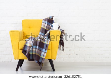 White wall texture with a retro yellow armchair