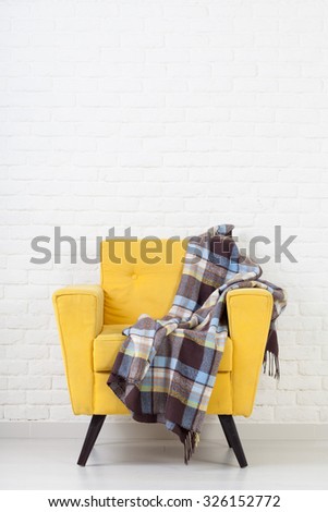 White wall texture with a retro yellow armchair