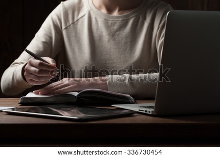 woman hands using laptop at office desk, with copyspace in dark space