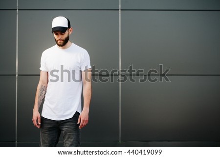 Hipster wearing white blank t-shirt and a baseball cap with space for your logo