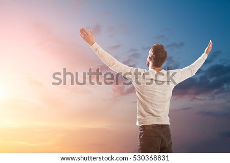 man holding up hands in order to praise God