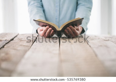 Hands turning the page of a bible