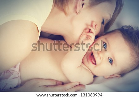 mother kissed her little baby, close-up