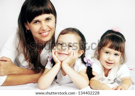 Happy mother and two daughters are on the floor