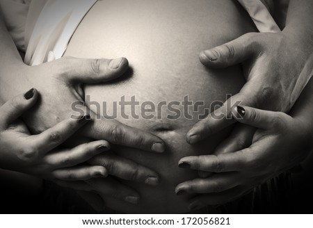Hands mom and dad hugging pregnant belly