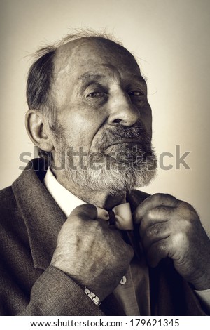 Portrait of an old man in a suit with a bow tie