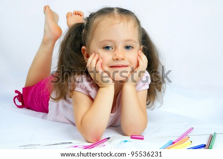 little pretty girl draws with markers on a white background isolated