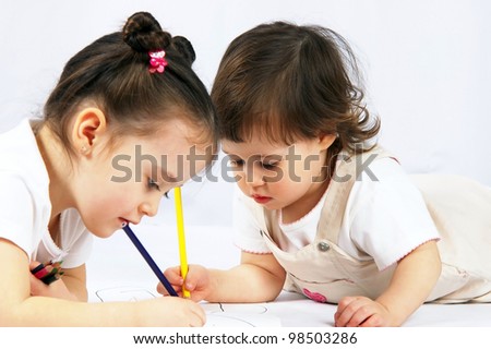 portrait of a two happy pretty girls with a pencils