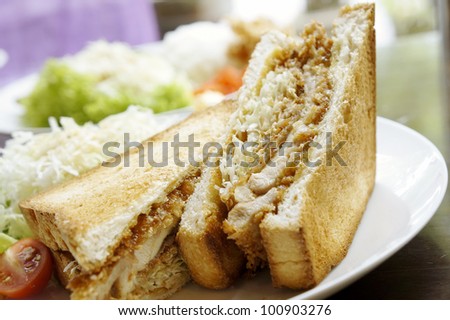 Japanese style chicken sandwich served with fresh vegetables.
