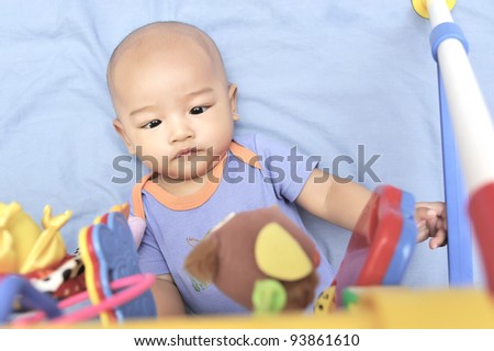 Cheerful cute baby boy playing with hanging toys.