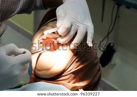 Close up of dental surgeon giving anesthetic to old lady patient.