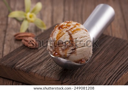 vanilla ice cream scoop with nuts, chocolate and caramel