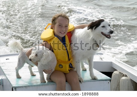 Young girl on boat with dogs