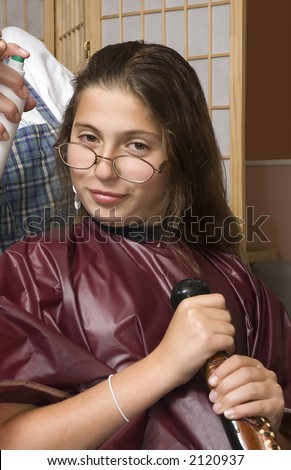 young girl wearing spectacles getting hair done