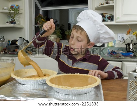 Young boy baking a pie for the holidays pouring ingredients into a pie shell with a label