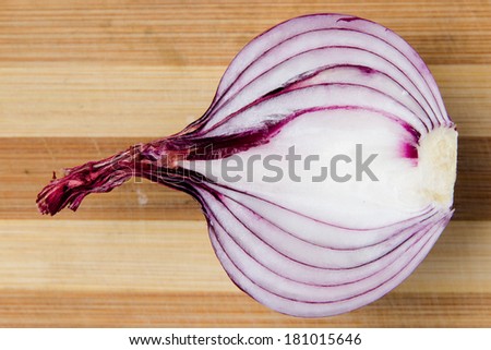 Purple onion slices on wooden board