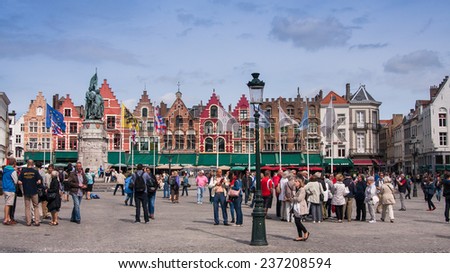 BRUGES, BELGIUM - 16 AUGUST 2014. Tourists walkins on Grote Markt  of Bruges, Brugge, meeting place of the Brugelings and tourists.