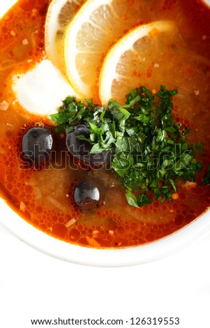 hot soup with sauce and lemon on white background