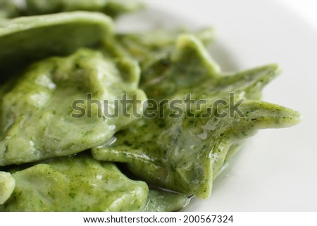white dish with basil and spinach ravioli