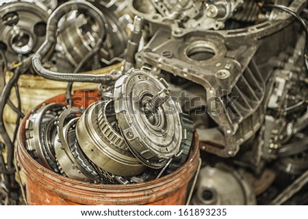 Bucket of used and worn out automobile parts.